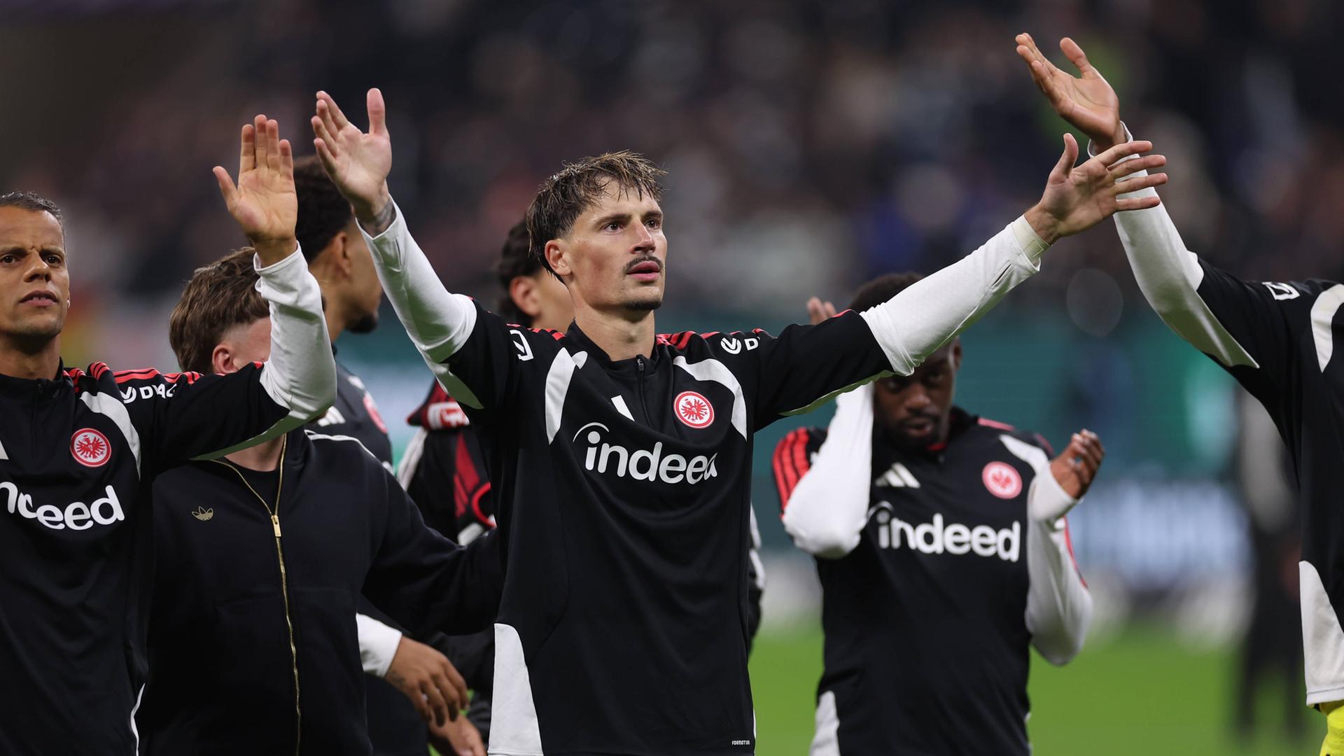 Eintracht-Kapitän Robin Koch feiert nach dem Sieg gegen Köln mit den Fans. | IMAGO / HMB-Media