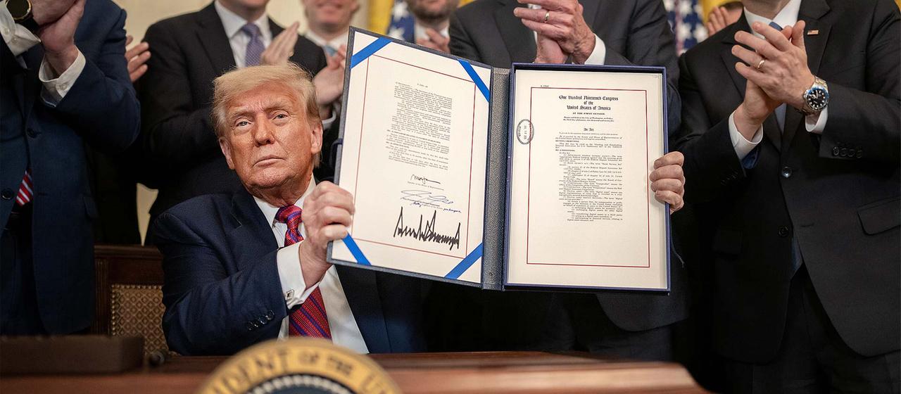Donald Trump hält das von ihm unterschriebene Dekret zum Genius Act hoch.