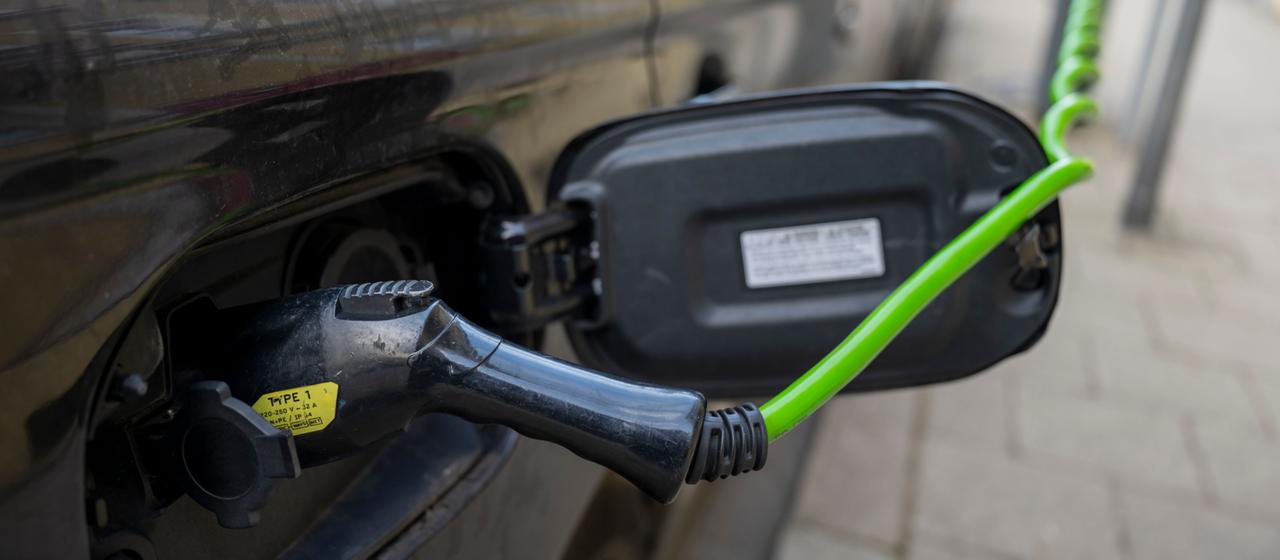 Ein Elektroauto hängt an einer Elektro-Ladesäule in der Innenstadt von München