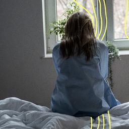 Einsame Frau sitzt allein auf dem Bett zu Hause.