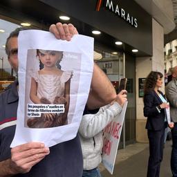 Ein Demonstrant hält ein Bild einer kindlichen Sexpuppe vor dem Kaufhaus BHV Marais in Paris.