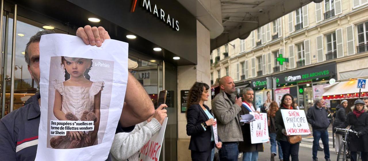 Ein Demonstrant hält ein Bild einer kindlichen Sexpuppe vor dem Kaufhaus BHV Marais in Paris.