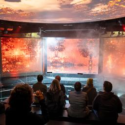 Museumsmitarbeiter und andere Personen sitzen auf der Erlebnisplattform während einer Vorab-Besichtigung in der noch im Aufbau befindlichen Ausstellung zum Thema Wetterextreme im Klimahaus in Bremerhaven.