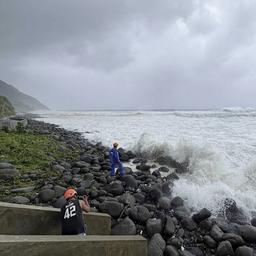 Menschen beobachten, wie starke Wellen auf Basco in der Provinz Batanes im Norden der Philippinen einschlagen.