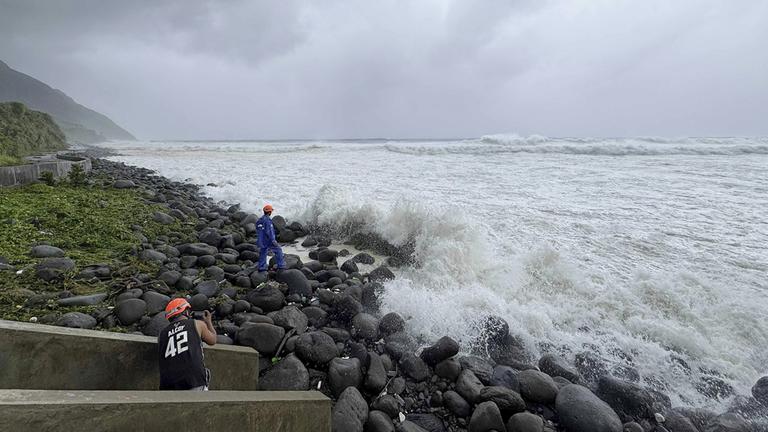 Menschen beobachten, wie starke Wellen auf Basco in der Provinz Batanes im Norden der Philippinen einschlagen.