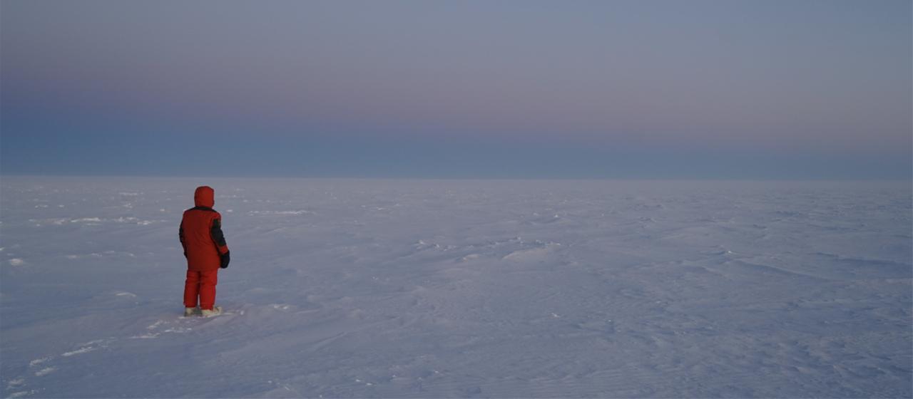 Eine Person steht in der Antarktis in der Nähe der Forschungsstation Concordia.