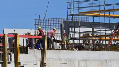 Bauarbeiter arbeiten auf einer Großbaustelle in München.