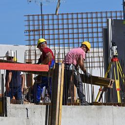 Bauarbeiter arbeiten auf einer Großbaustelle in München.