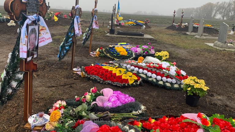 Die frischen Gräber auf dem Friedhof des Dorfes Hrosa haben das gleiche Todesdatum, der Tag des russischen Raketenangriffs.