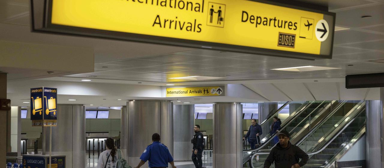 Menschen mit Koffern gehen durch das internationale Terminal des Newark Liberty International Airport.