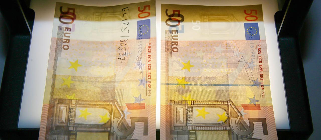 A fake and a real fifty lie on a light device (archive image).