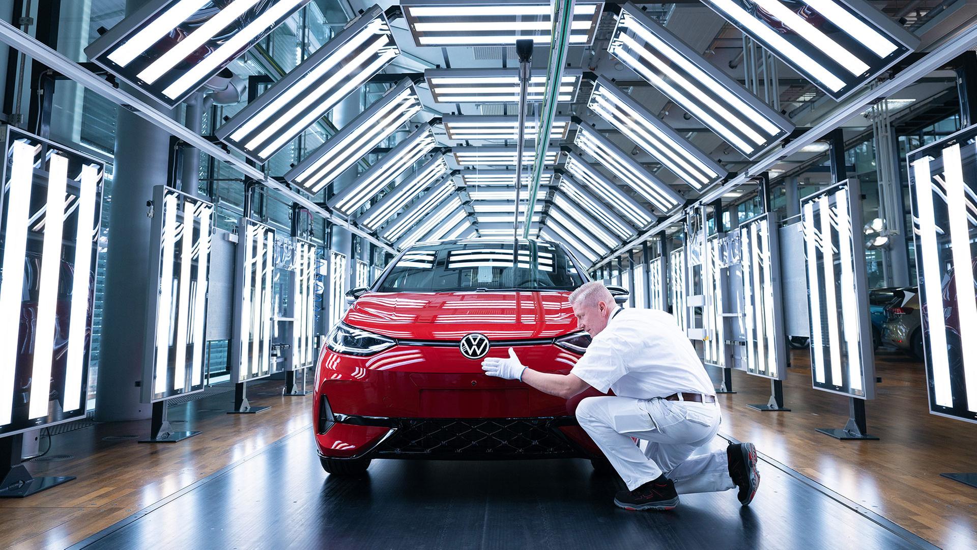 Ein Mitarbeiter von Volkswagen inspiziert  im Lichttunnel  einen VW ID.3. | picture alliance/dpa