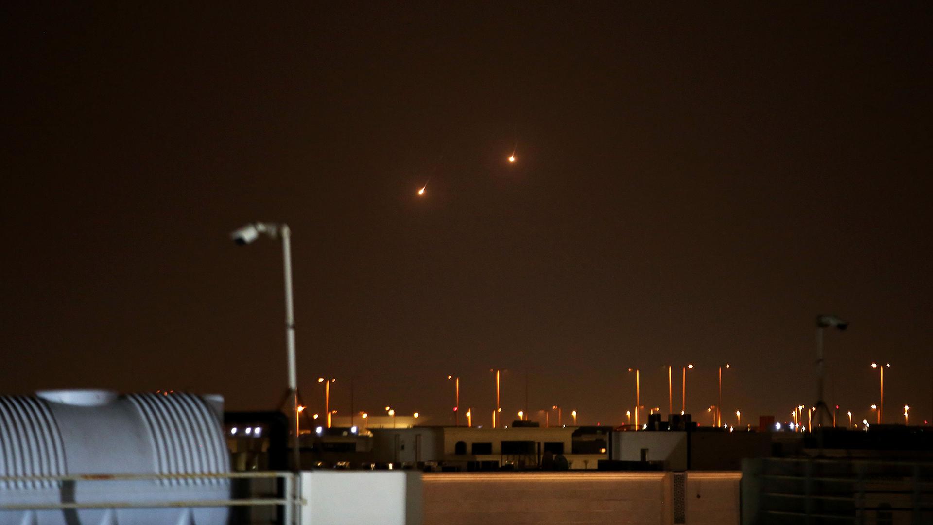 Die Lichter zweier Abfangraketen sind am Nachthimmel zu sehen. | Stringer/dpa