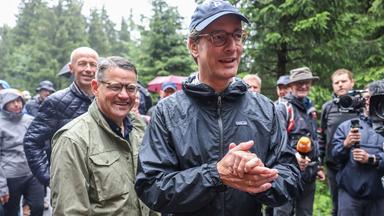 Hendrik Wüst (r, CDU), Ministerpräsident von Nordrhein-Westfalen, und Boris Rhein (l, CDU), Ministerpräsident in Hessen, gehen in der Nähe von Winterberg durch den Wald.