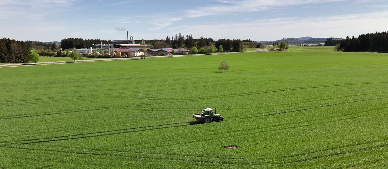 Un tractor atraviesa un campo delante de la planta de reciclaje de fósforo en Altenstadt.
