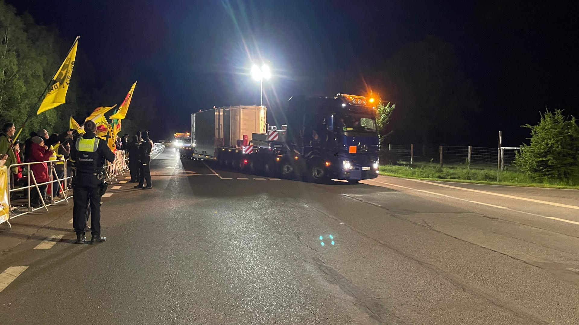 der Castortransport rollt in Ahaus ein und Demonstranten stehen mit Fahnen am Rand  | WDR / Mühlenbrock