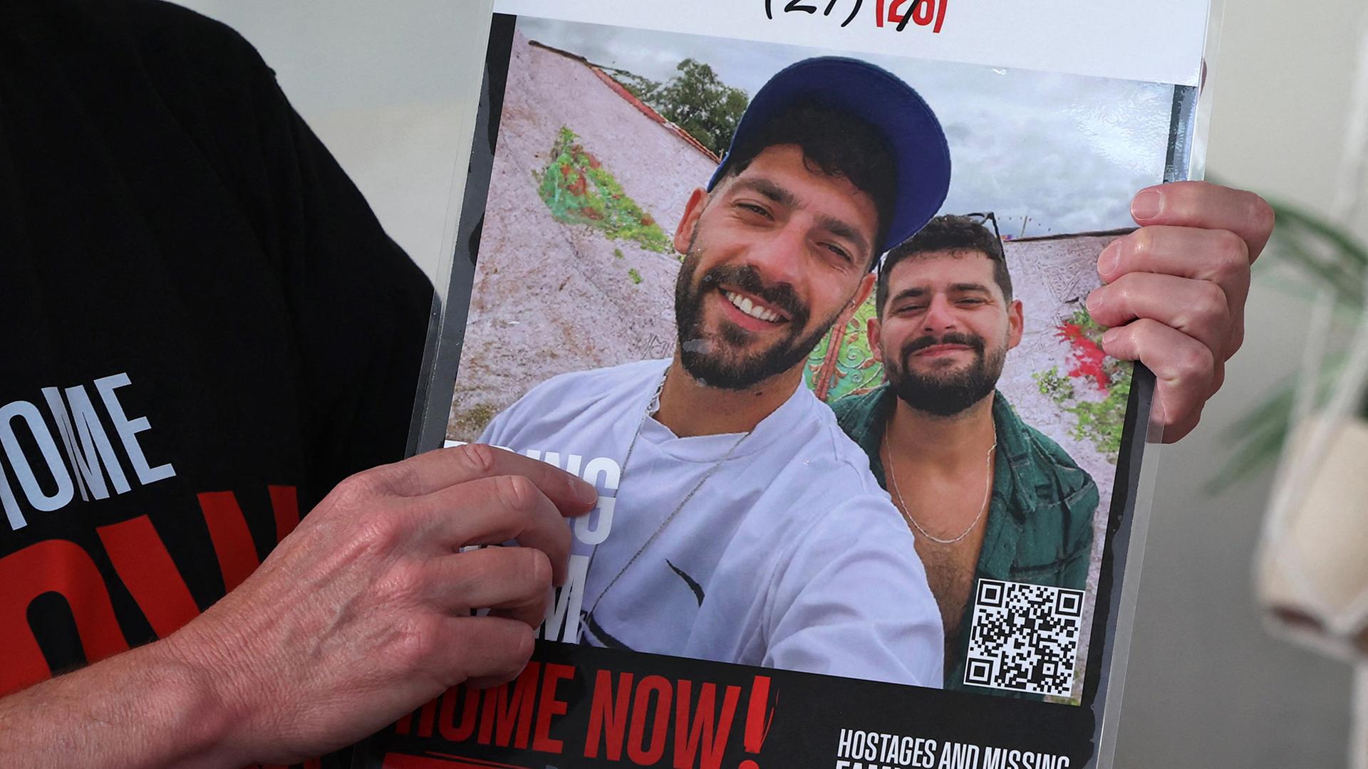 Ein Foto der israelischen Geiseln Gali und Ziv Berman ist auf einem Plakat zu sehen. | AFP