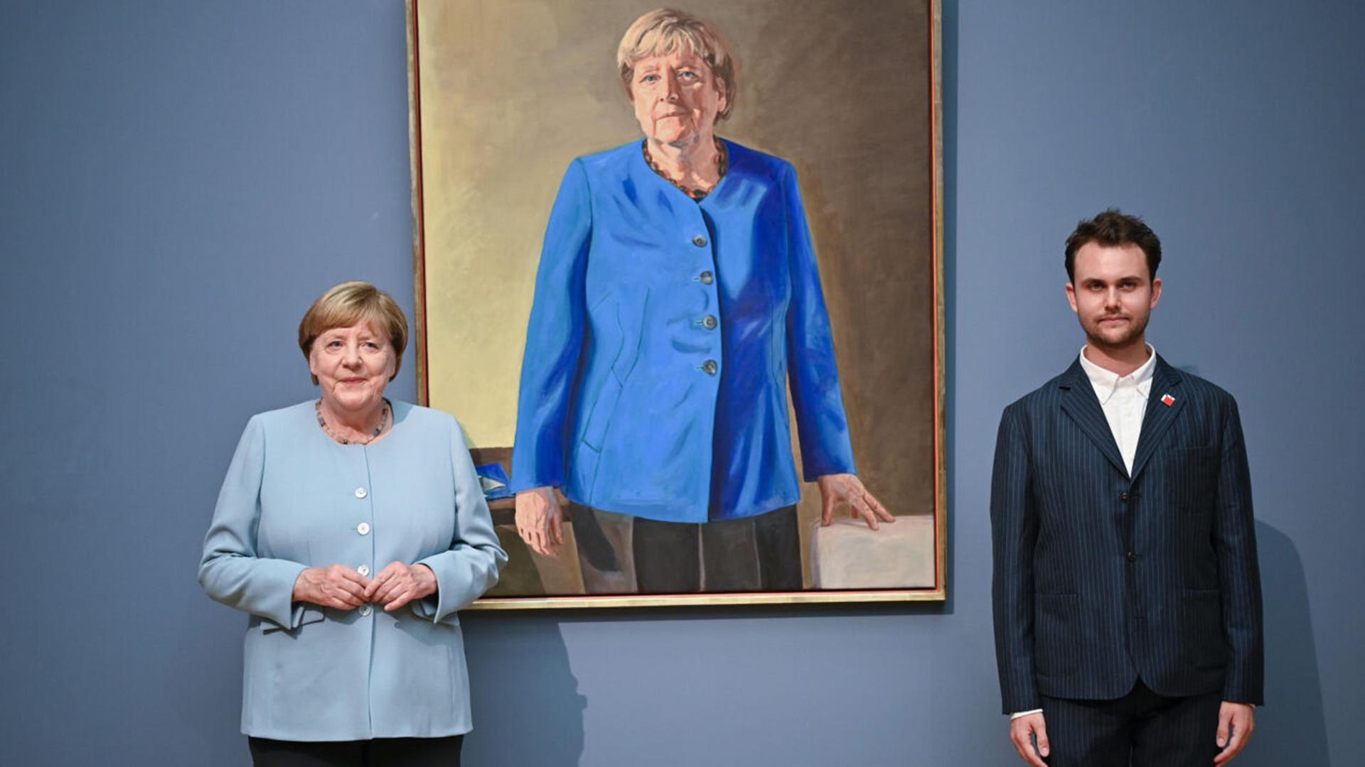 Angela Merkel und Maler Jeremie Queyras stehen vor dem Porträt der früheren Bundeskanzlerin (Quelle: dpa/Ditsch)  | dpa/Ditsch