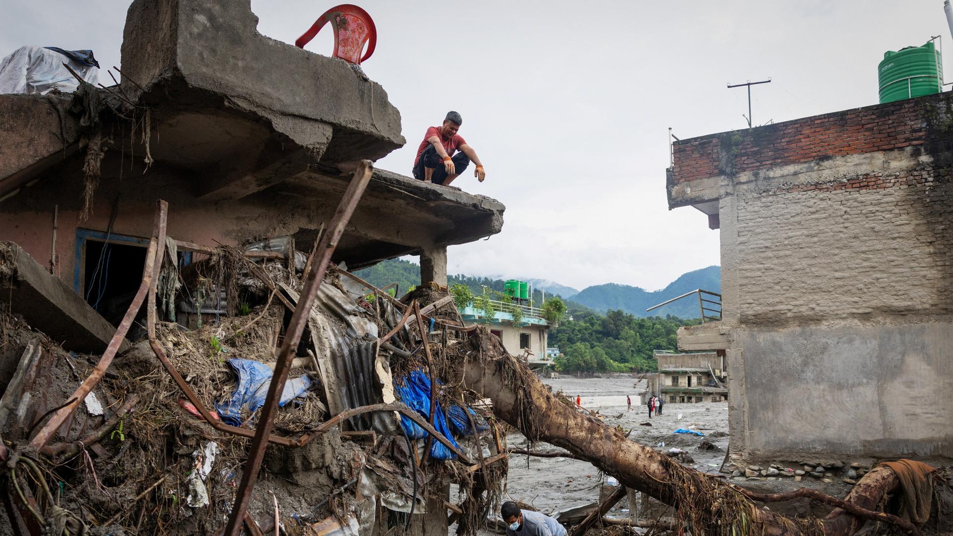 Menschen suchen in ihrem zerstörten Haus in Nepal nach Habseligkeiten. | REUTERS