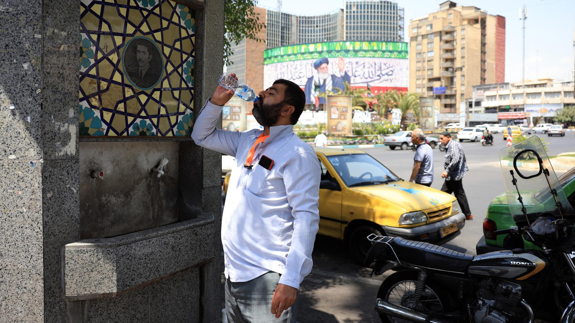 Ein Mann trinkt an einem Wasserspender in Teheran.  | EPA