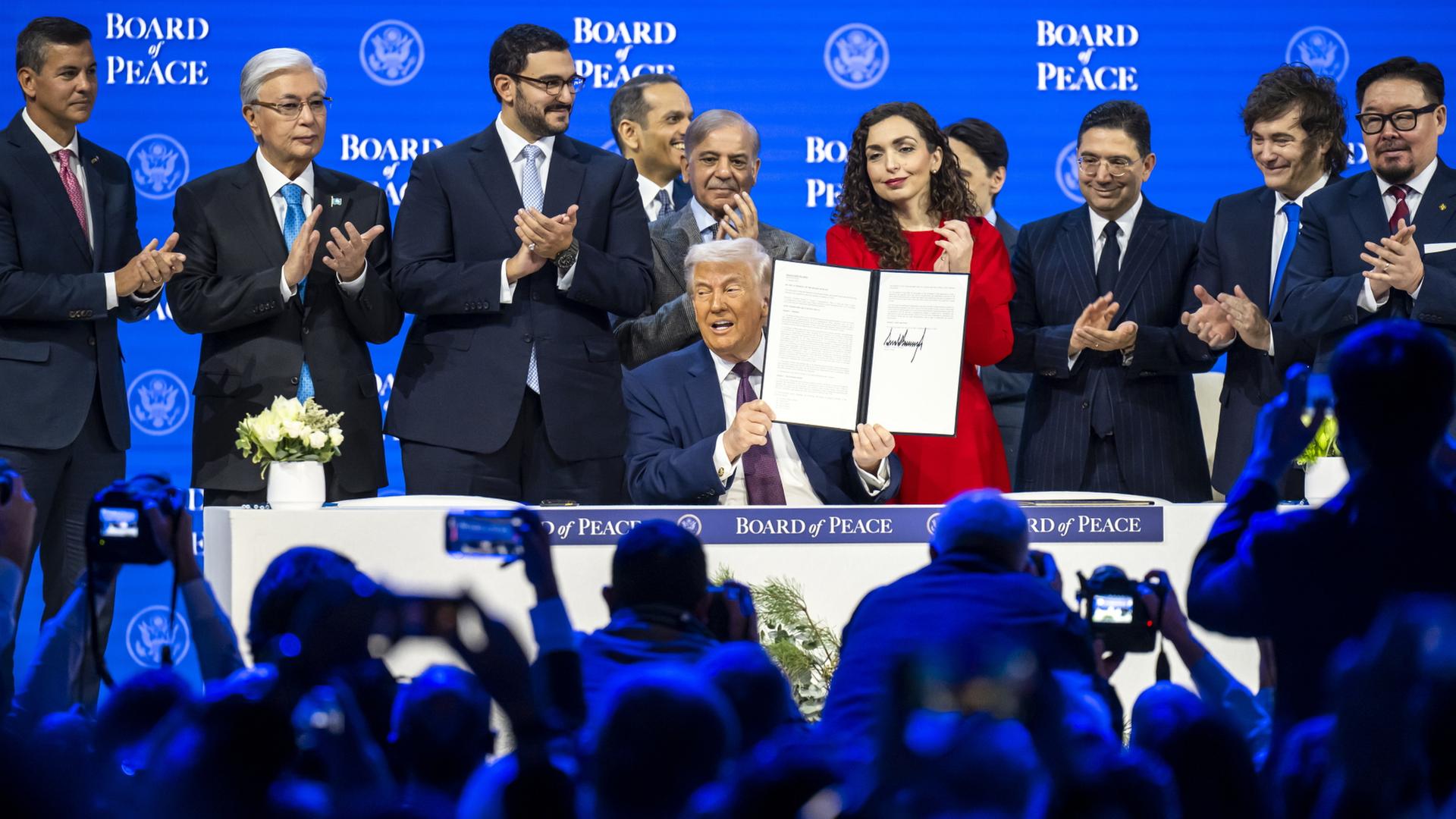 Trump zeigt in Davos zusammen mit anderen Staats- und Regierungschefs das unterzeichnete Gründungsdokument für den 