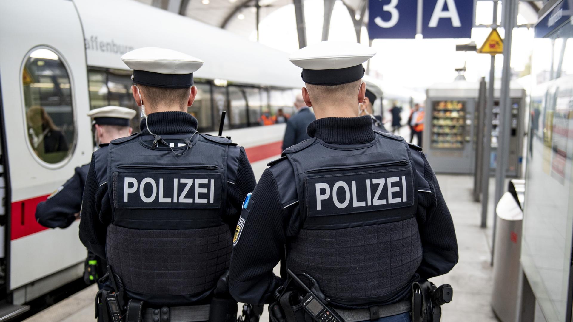 Zwei Bundespolizisten stehen am Gleis vor der Abfahrt eines ICE am Kieler Hauptbahnhof. | dpa