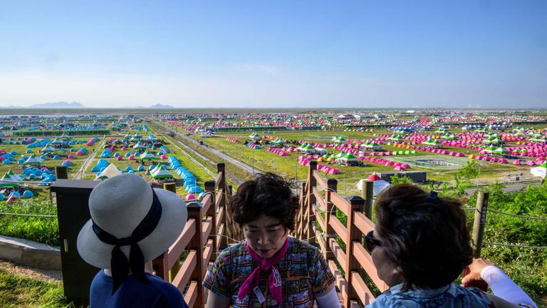 Besucher schauen von einer Plattfrom auf das riesige Pfadfinderlager.