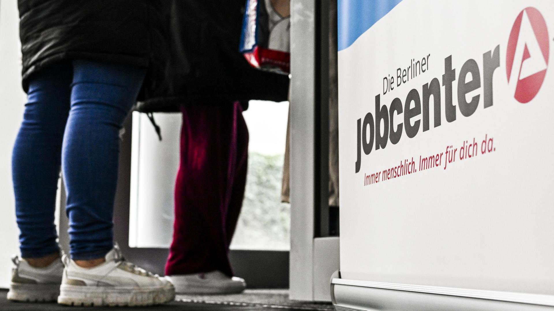 Menschen stehen am Eingang eines Jobcenters | dpa-tmn