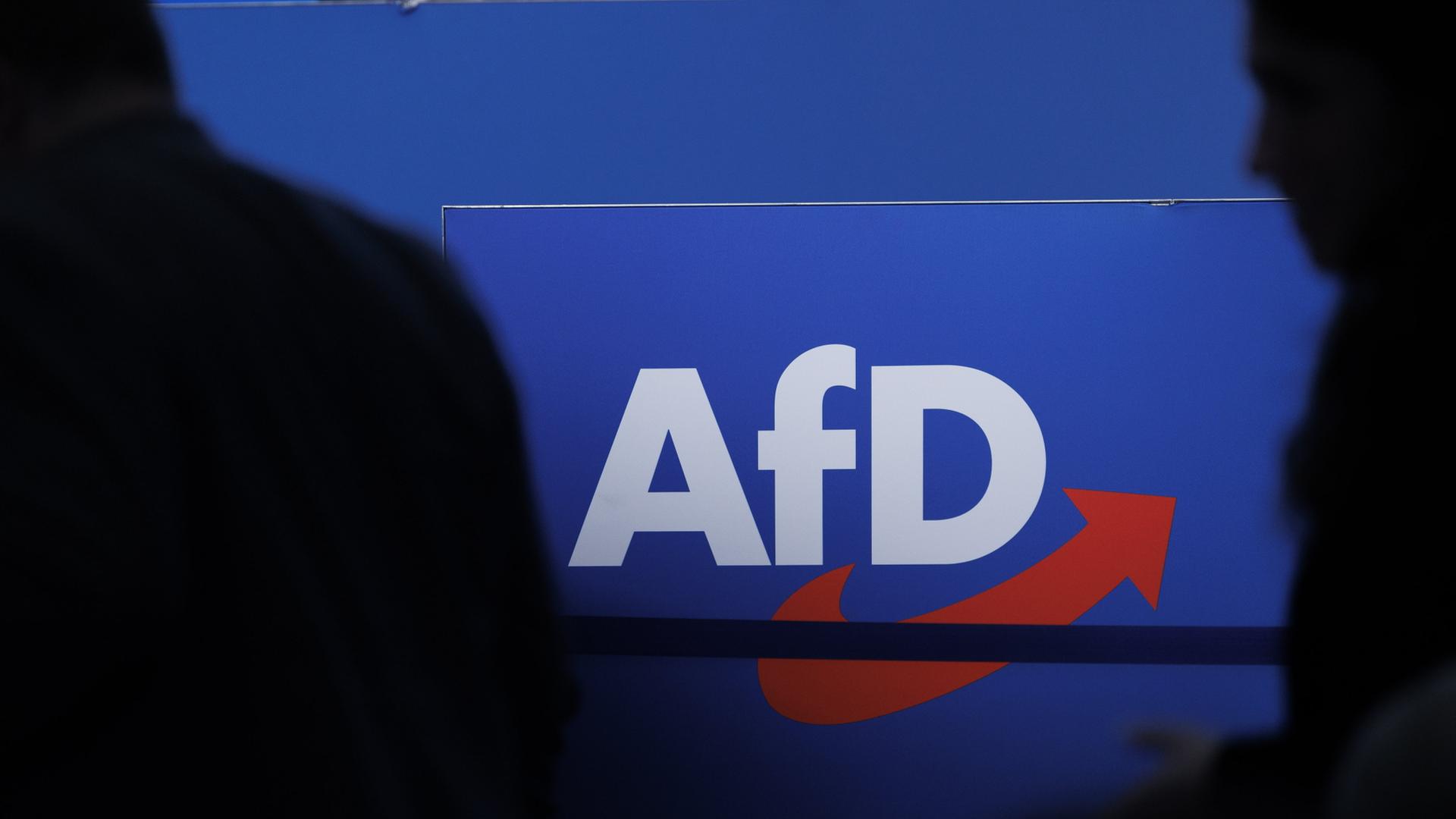 Die Silhouetten von zwei Personen vor dem AfD-Logo | dpa