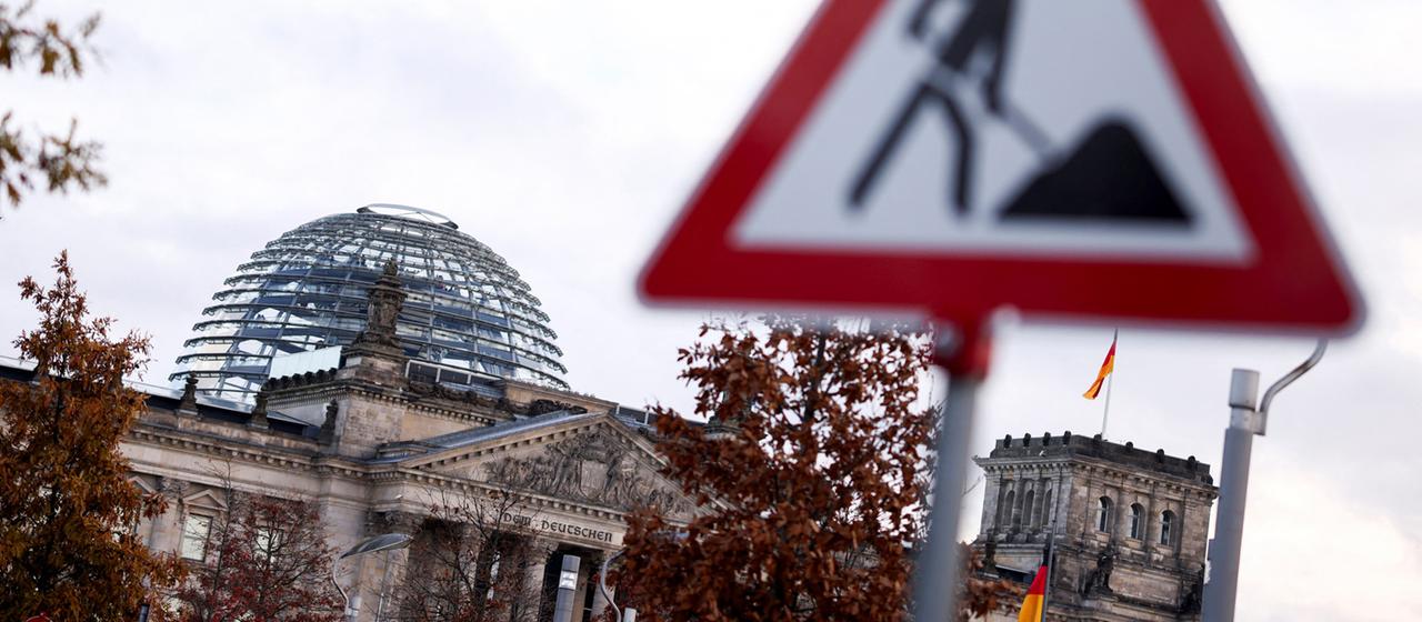Ein Baustellenschild steht vor dem Reichstagsgebäude in Berlin.
