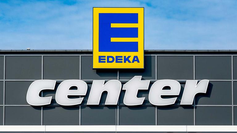 Unternehmenslogo an der Fassade einer Edeka-Filiale.