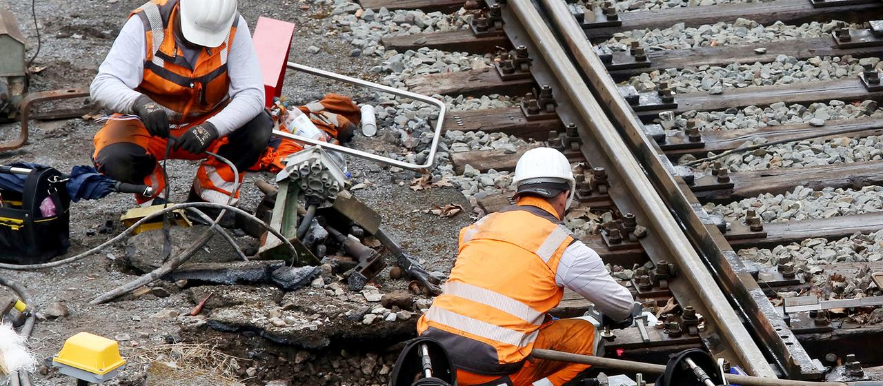 Arbeiter reparieren auf der Strecke zwischen Essen und Duisburg das Schienennetz.