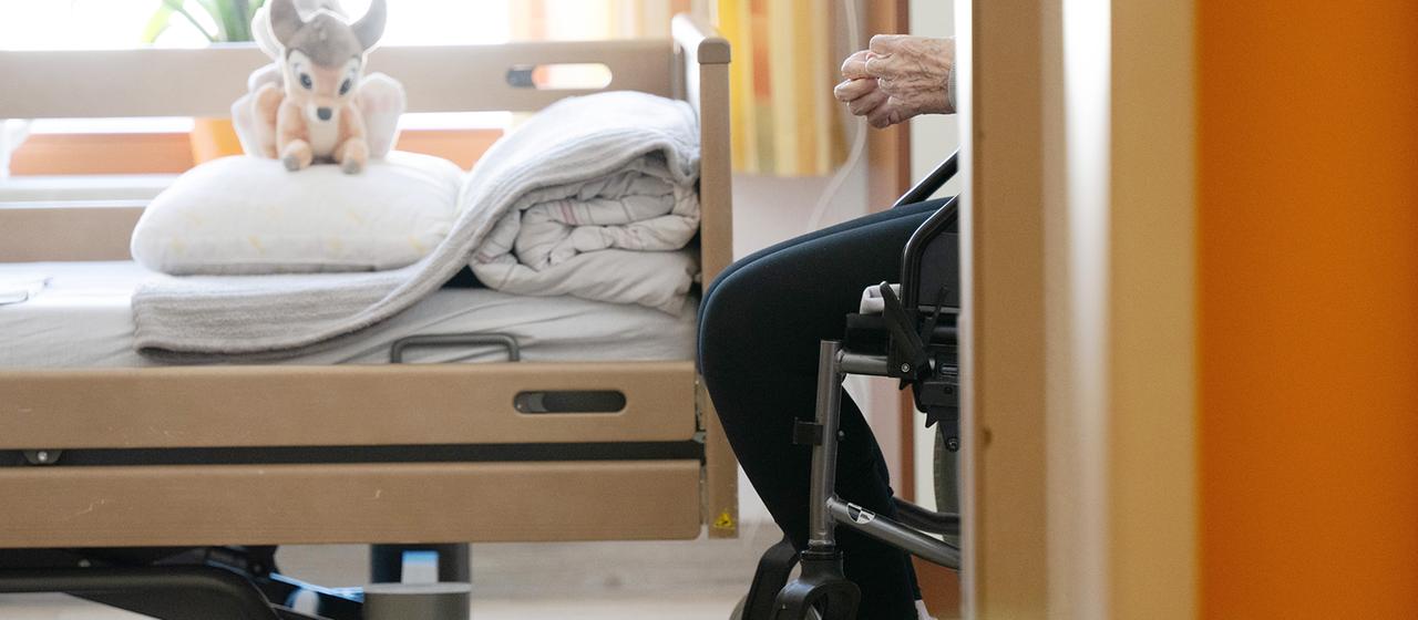 Ein Bewohner sitzt in einem Altenheim in seinem Zimmer in einem Rollstuhl.