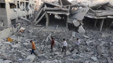 Menschen inspizieren ein zerstörtes Haus in Gaza-Stadt. 