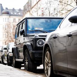 Ein SUV steht geparkt zwischen kleineren Fahrzeugen auf einem Parkstreifen.