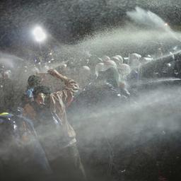 Protestierende ducken sich, als Polizisten bei einer Demonstration in Istanbul Pfefferspray einsetzt.