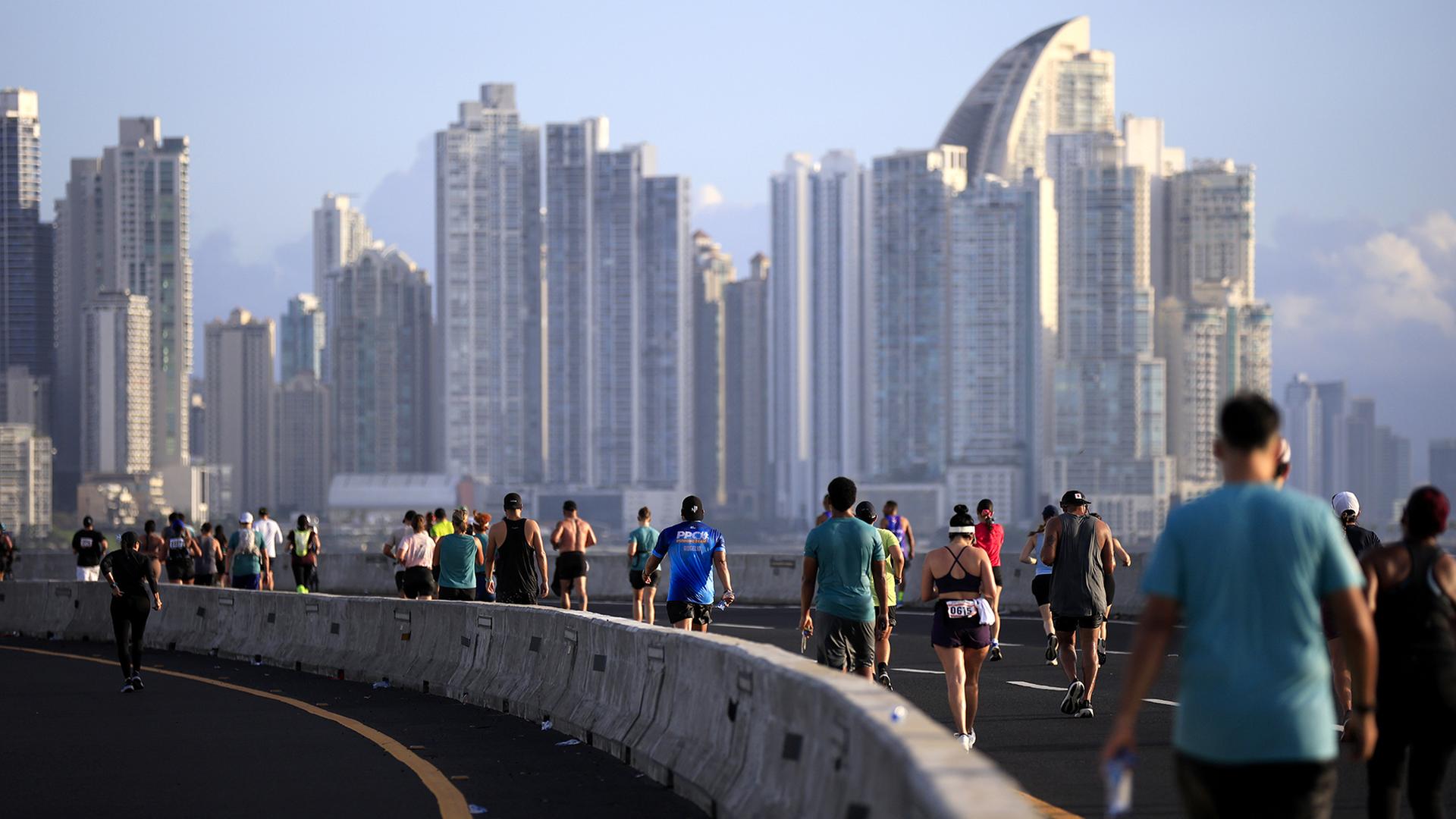 Teilnehmer eines Marathons laufen vor einer Skyline. | EPA