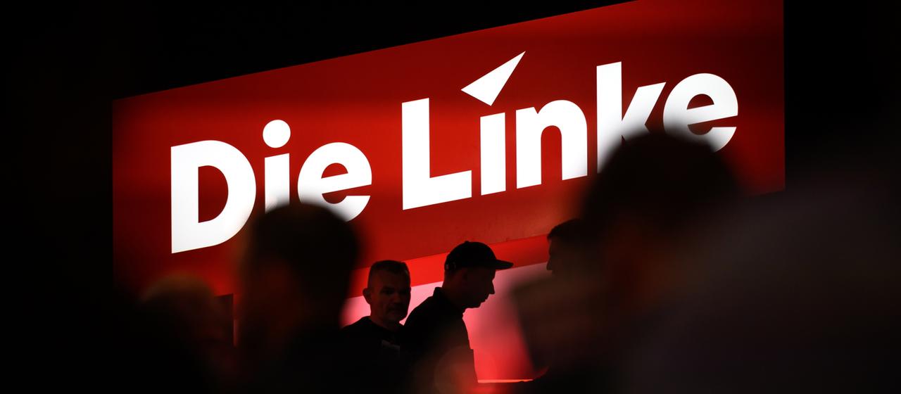 Delegierte sitzen auf dem Bundesparteitag unter dem Logo der Partei