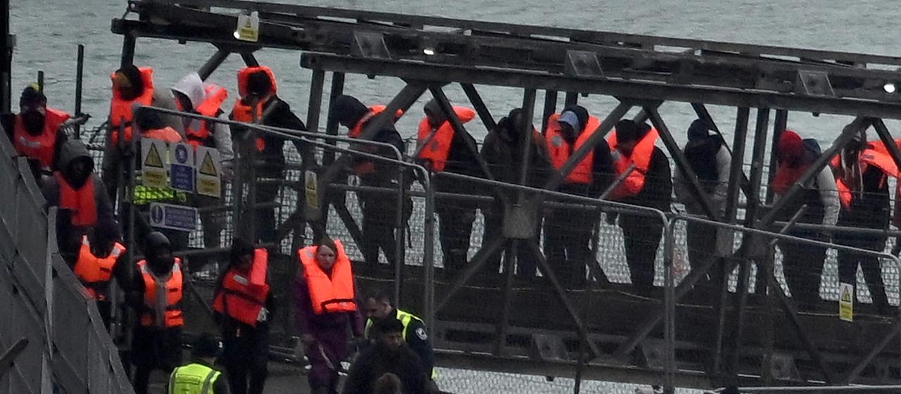 Migranten gehen in Dover von Bord eines Schiffes der Grenzschutzbehörde.