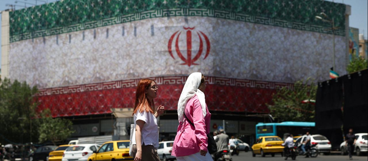 Eine Straßenszene in der iranischen Hauptstadt Teheran mit einem riesigen Banner der Flagge Irans. 