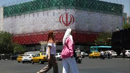 Eine Straßenszene in der iranischen Hauptstadt Teheran mit einem riesigen Banner der Flagge Irans.