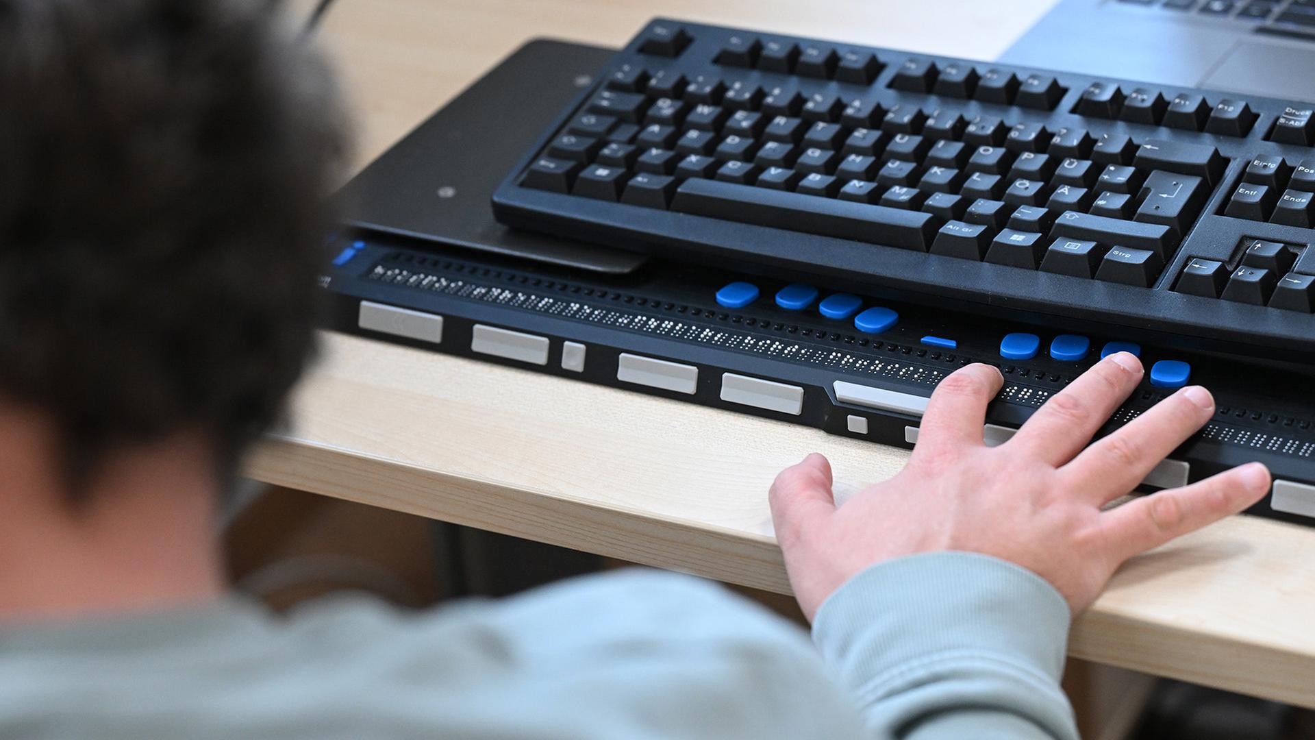 Eine Person bedient eine Braillezeile an einem Computer. | picture alliance/dpa
