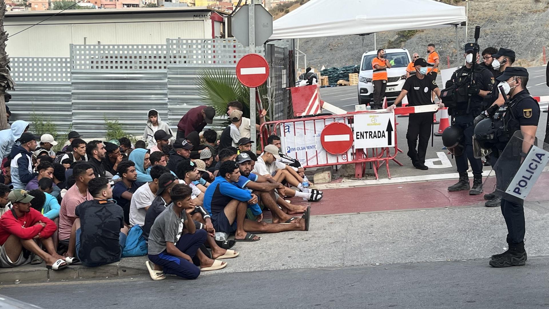 Migranten warten vor der Notunterkunft 