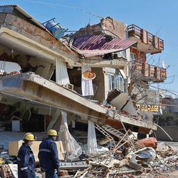 Rettungskräfte vor einem vom Erdbeben beschädigten Gebäudes in Kahramanmaras, Türkei.