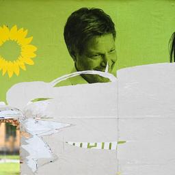 Ein zerstörtes Wahlplakat von Bündnis 90/Die Grünen mit den Portraits von Robert Habeck und Annalena Baerbock.