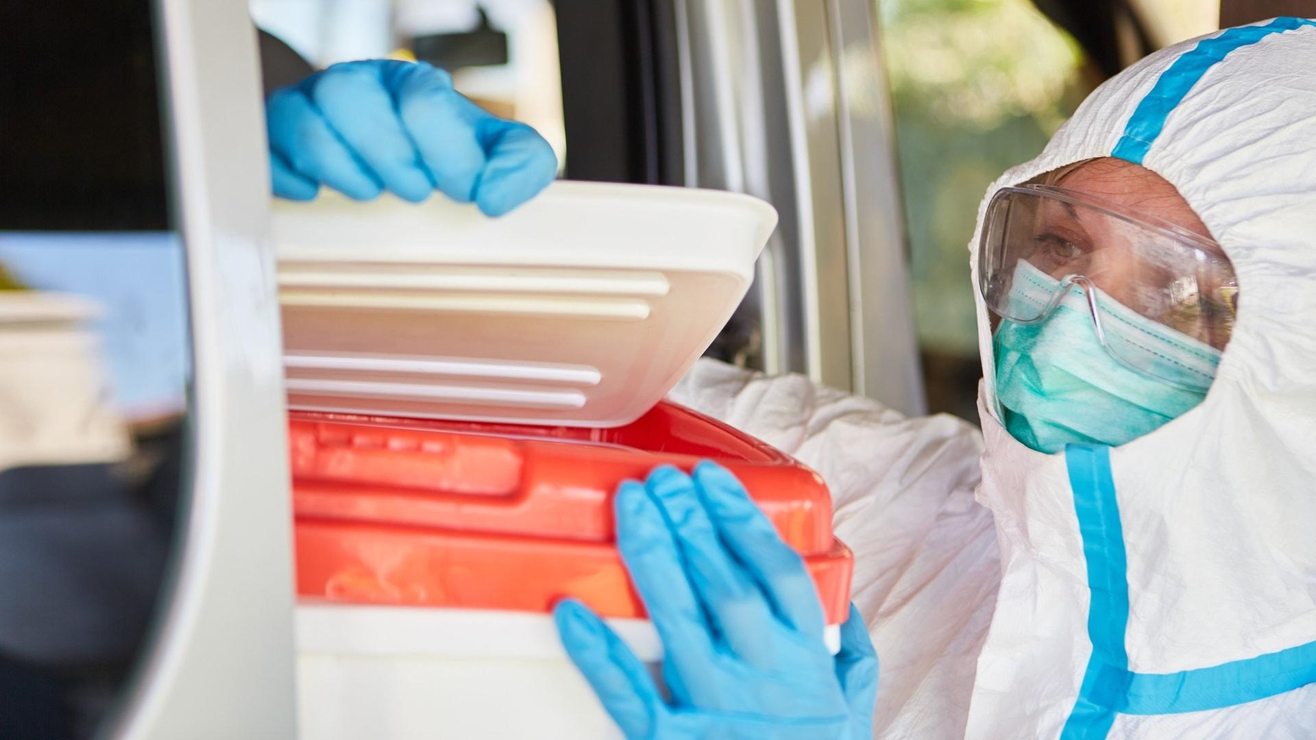 Eine Medizinerin in Schutzkleidung überprüft eine Organspende (Symboldbild).  | picture-alliance / Reportdienste, picture alliance / Zoonar | Robert Kneschke