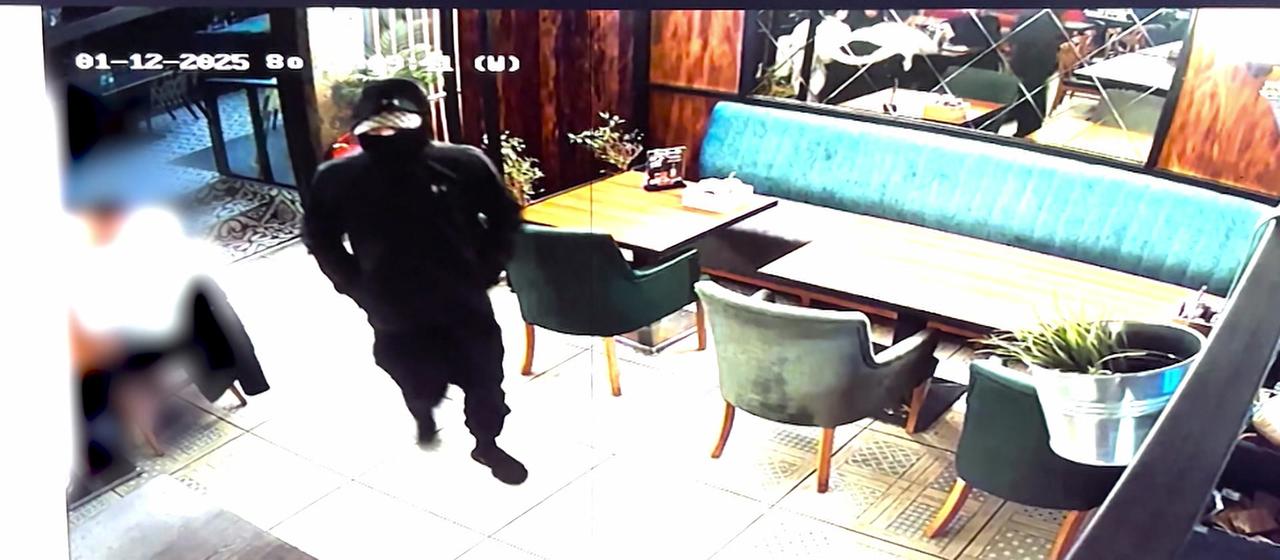 Vermummter Jugendlicher in einem Restaurant