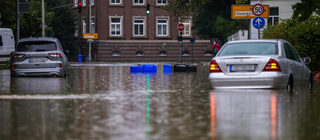 Zwei Autos stehen in einer überschwemmten Straße in Mönchengladbach-Rheydt