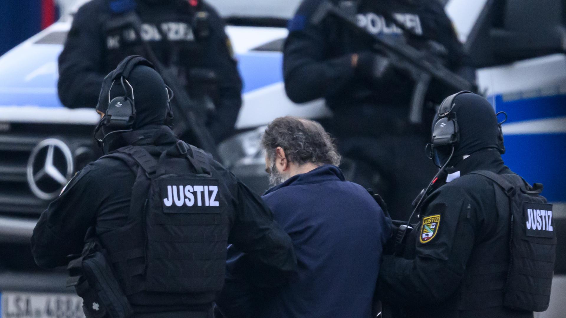 Der Angeklagte im Prozess auf den Anschlag auf den Magdeburger Weihnachtsmarkt wird von Polizisten zum Gerichtsgebäude geführt | dpa