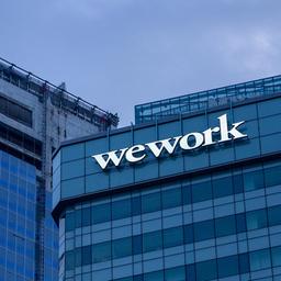 WeWork-Unternehmenslogo an einer Hochhausfassade.